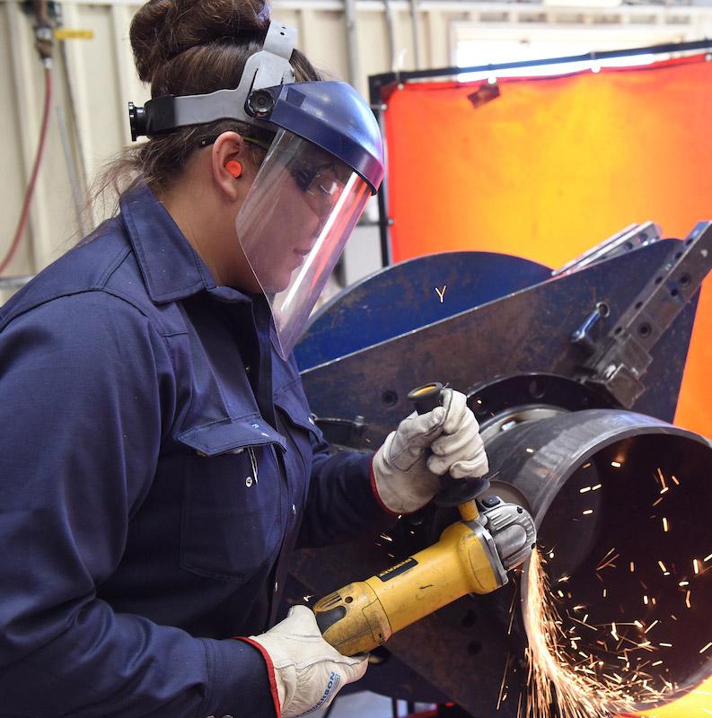 Pipefitter grinding a pipe